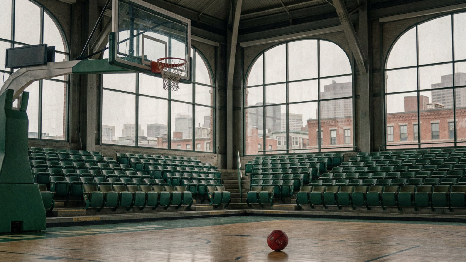 An editorial illustration of a basketball and hoop inside an empty TD Garden-inspired arena with green seating, without people, logos or text.