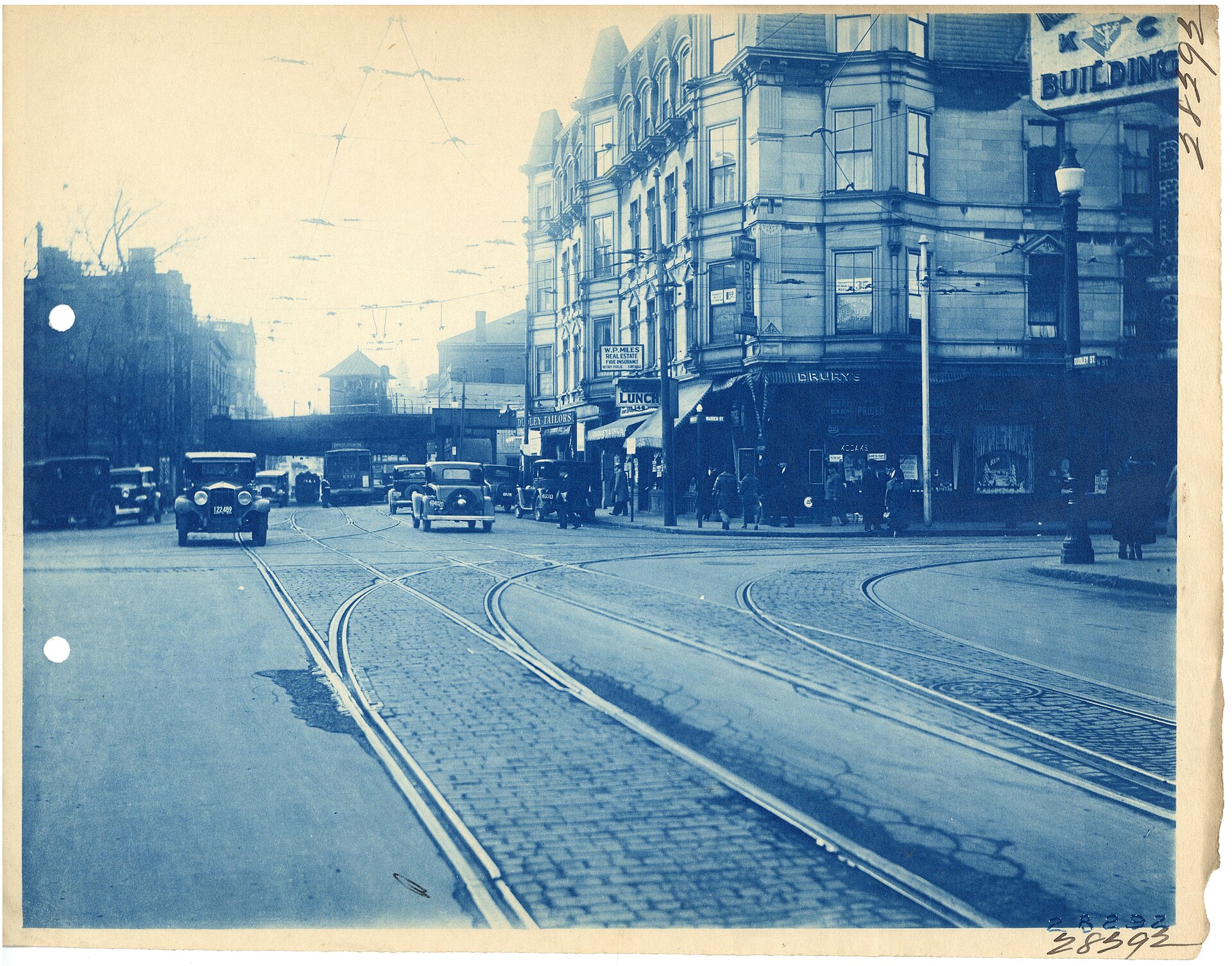 Historic cyanotype of streetcar tracks, early automobiles and storefronts at Dudley Square in Roxbury