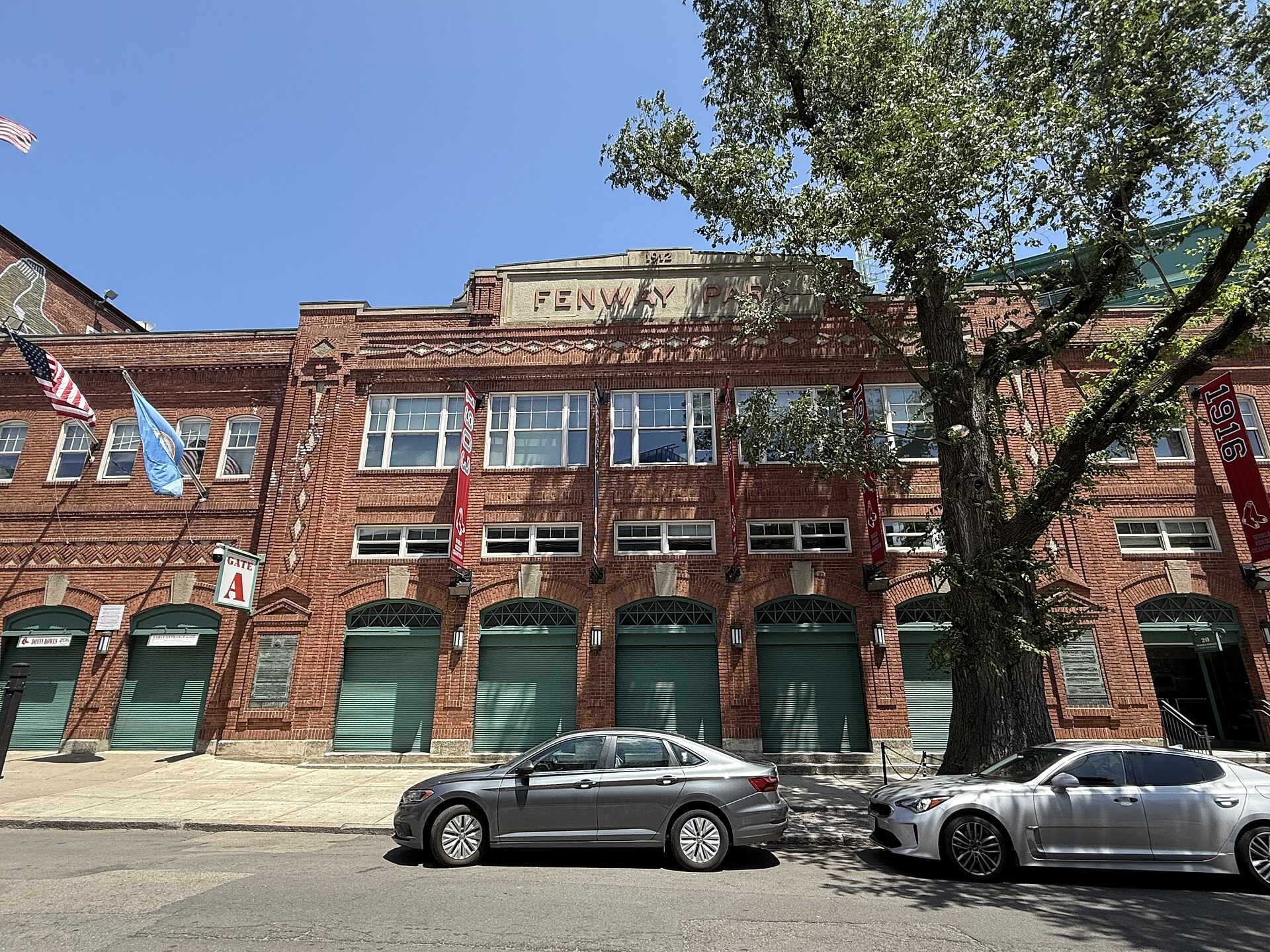 Fenway Park's red-brick exterior with green garage doors and flags