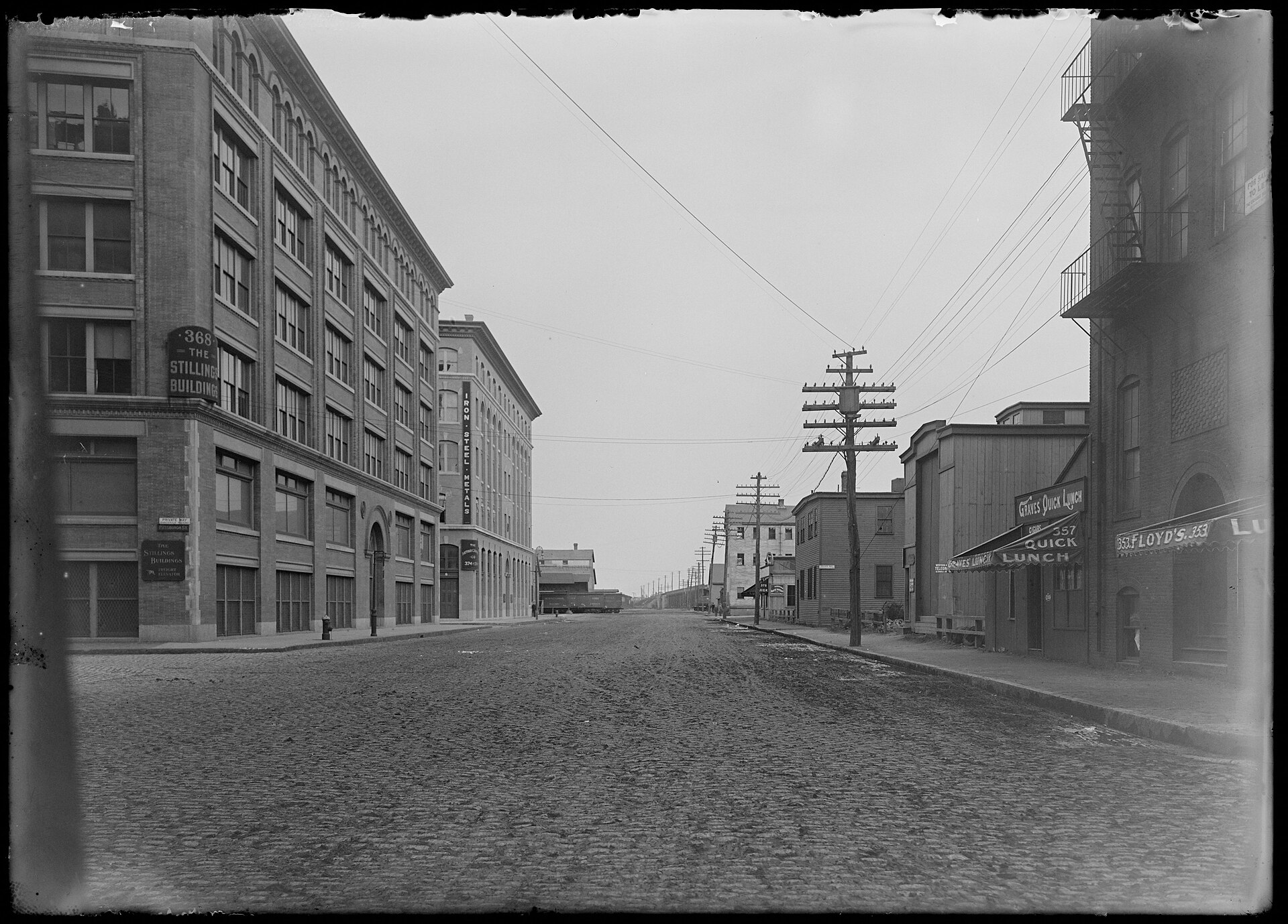 Historic photo of brick warehouse buildings along a cobblestone Congress Street in Fort Point