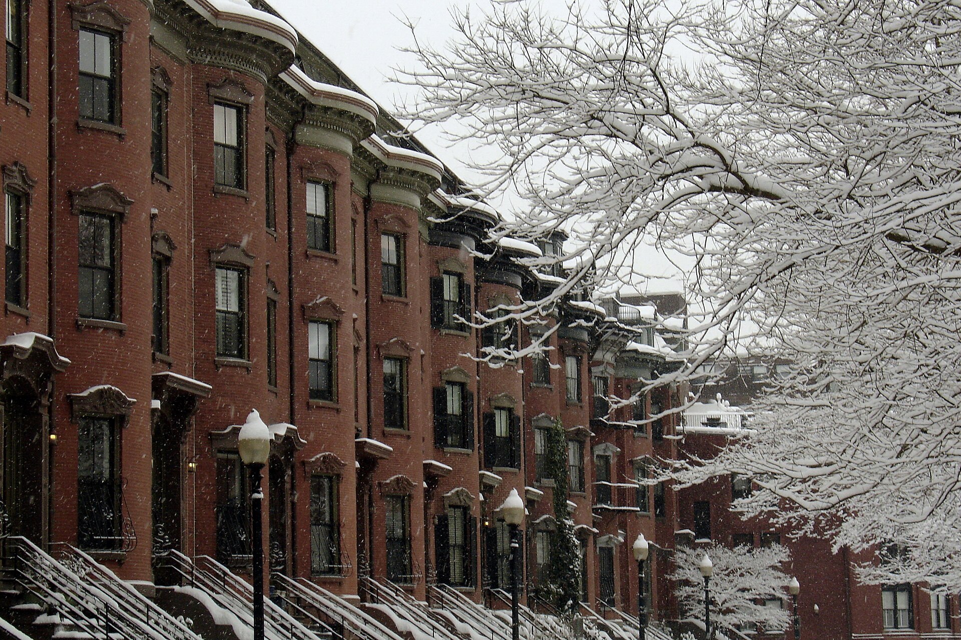 Snow-dusted rows of red-brick bowfront rowhouses with stoops on Worcester Square
