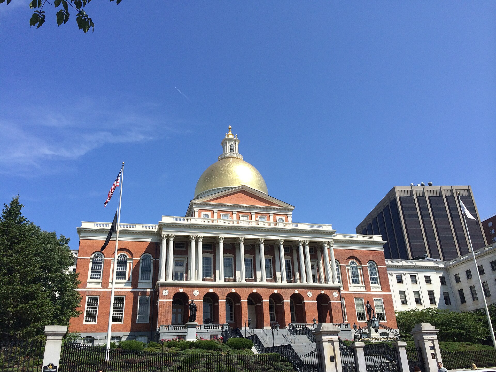 The red-brick Massachusetts State House with its gold dome under a blue sky